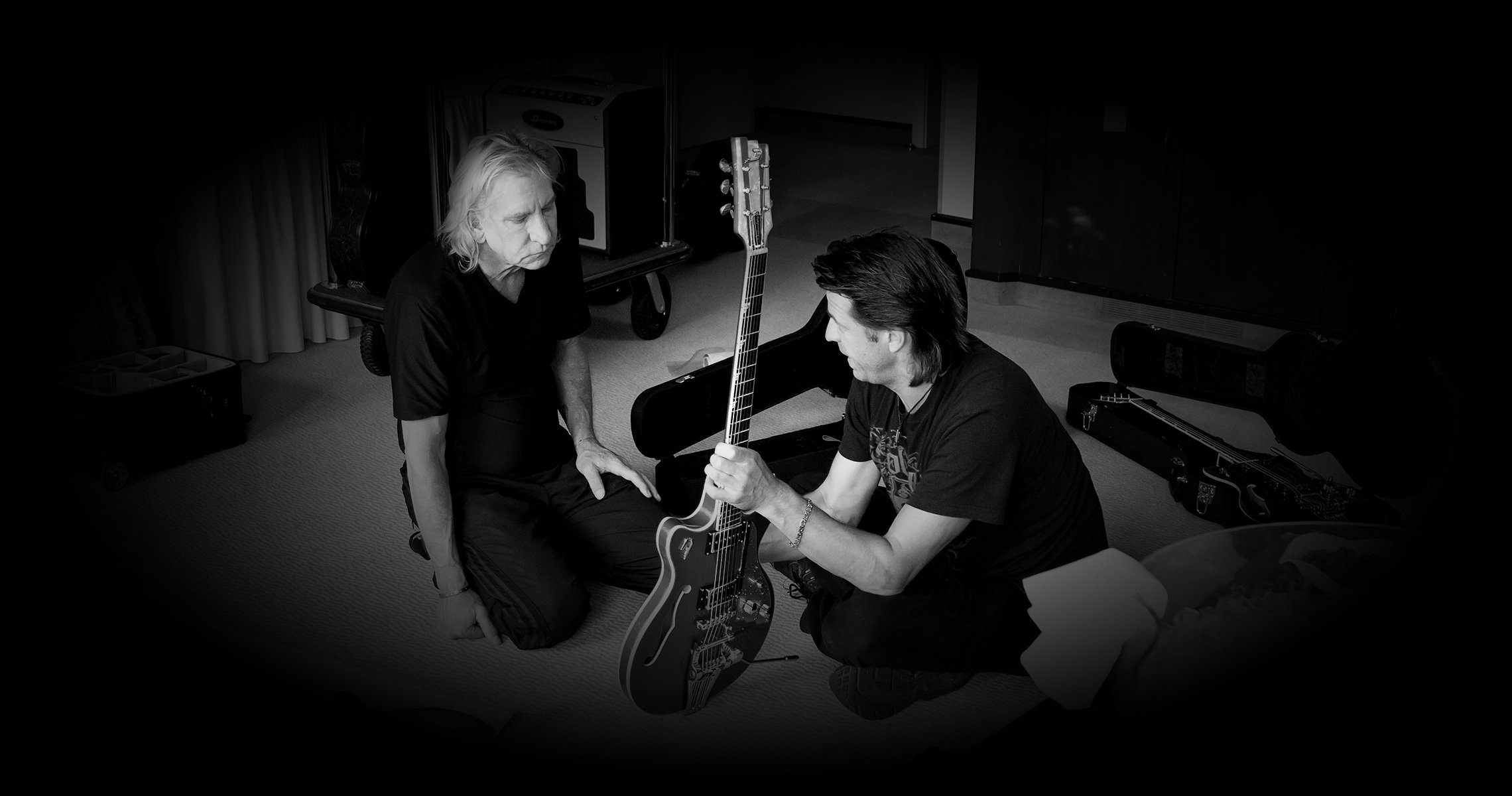 Photo of Joe Walsh and Duesenberg CEO Ingo Renner in a Hotel room discussing guitars